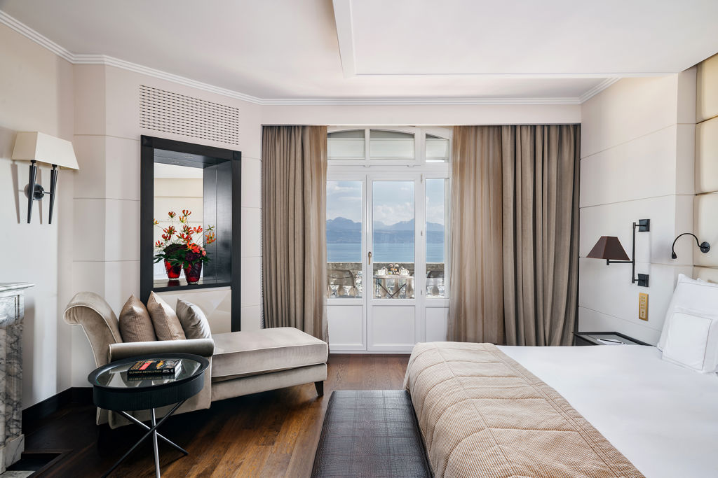 Master bedroom de la Samaranch Suite du Lausanne Palace, avec lit king-size, larges fenêtres ouvertes sur le lac Léman et les Alpes suisses. Une Signature Suite de prestige offrant une expérience résidentielle unique dans un palace historique au cœur de Lausanne.