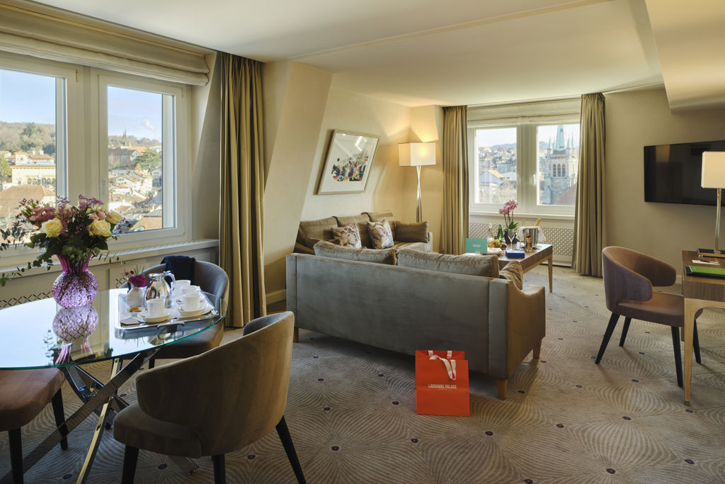 Espace de vie d'une Corner Suite City du Lausanne Palace, baigné de lumière naturelle et offrant plusieurs points de vue sur Lausanne. Cette suite spacieuse avec salon, balcon privatif selon les catégories et mobilier contemporain crée une véritable expérience résidentielle au cœur du centre-ville.