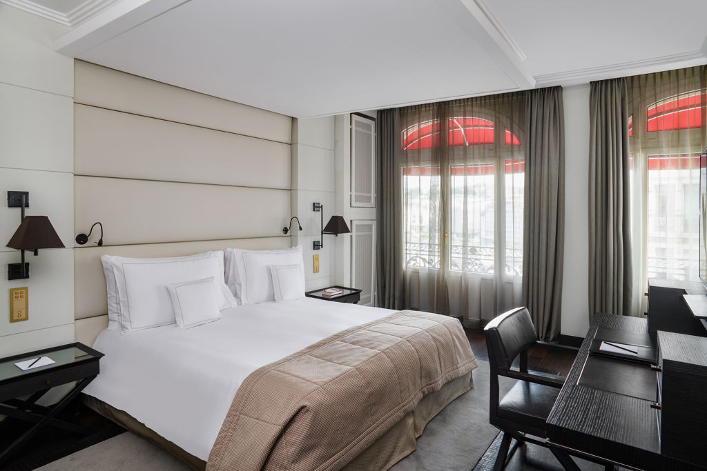 Espace nuit d'une Junior Suite City View du Lausanne Palace, associant volumes généreux, mobilier élégant et ambiance chaleureuse. Cette suite avec vue sur la ville de Lausanne offre une expérience premium dans un hôtel emblématique situé à proximité de la Place Saint-François, du lac Léman et de la cathédrale de Lausanne.